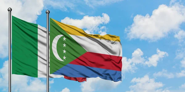 Bandera de Italia y Comoras ondeando en el viento contra el cielo azul nublado blanco juntos. Concepto diplomático, relaciones internacionales . — Foto de Stock