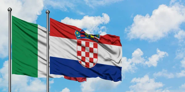 Bandera de Italia y Croacia ondeando en el viento contra el cielo azul nublado blanco juntos. Concepto diplomático, relaciones internacionales . — Foto de Stock