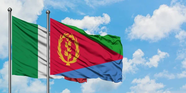 Bandera de Italia y Eritrea ondeando en el viento contra el cielo azul nublado blanco juntos. Concepto diplomático, relaciones internacionales . — Foto de Stock