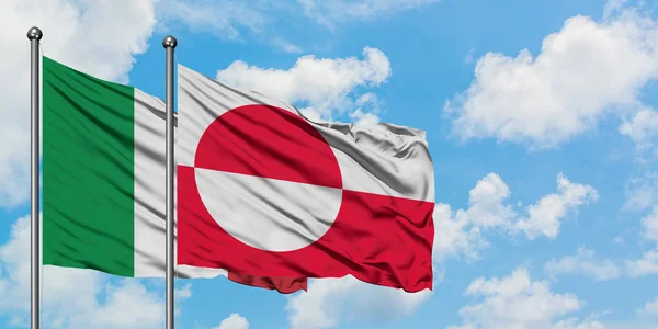 Bandera de Italia y Groenlandia ondeando en el viento contra el cielo azul nublado blanco juntos. Concepto diplomático, relaciones internacionales . — Foto de Stock