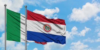 İtalya ve Paraguay bayrağı rüzgarda dalgalanırken beyaz bulutlu gökyüzüne karşı birlikte. Diplomasi kavramı, uluslararası ilişkiler.