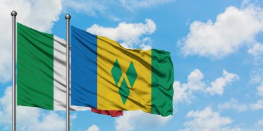 İtalya ve Saint Vincent ve Grenadines bayrağı rüzgarda dalgalanan beyaz bulutlu mavi gökyüzüne karşı birlikte. Diplomasi kavramı, uluslararası ilişkiler.