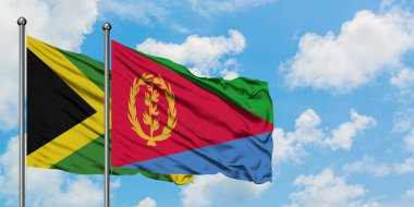 Jamaika ve Eritre bayrağı birlikte beyaz bulutlu mavi gökyüzüne karşı rüzgarda sallayarak. Diplomasi kavramı, uluslararası ilişkiler.