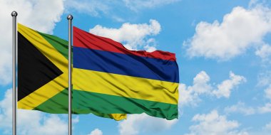 Jamaika ve Mauritius bayrağı birlikte beyaz bulutlu mavi gökyüzüne karşı rüzgarda sallayarak. Diplomasi kavramı, uluslararası ilişkiler.