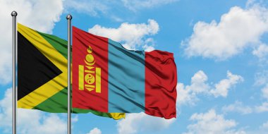 Jamaika ve Moğolistan bayrağı birlikte beyaz bulutlu mavi gökyüzüne karşı rüzgarda sallayarak. Diplomasi kavramı, uluslararası ilişkiler.