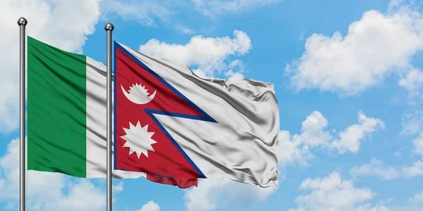 Bandera de Italia y Nepal ondeando en el viento contra el cielo azul nublado blanco juntos. Concepto diplomático, relaciones internacionales . — Foto de Stock