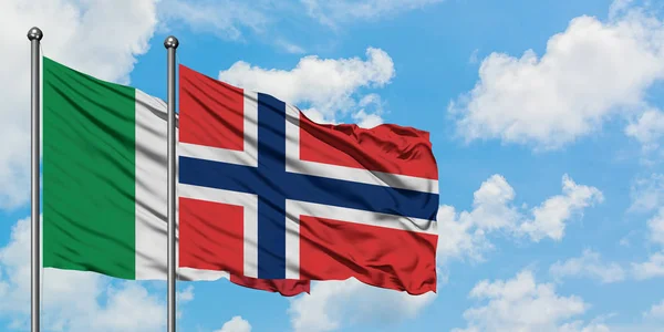 Bandera de Italia y Noruega ondeando en el viento contra el cielo azul nublado blanco juntos. Concepto diplomático, relaciones internacionales . — Foto de Stock