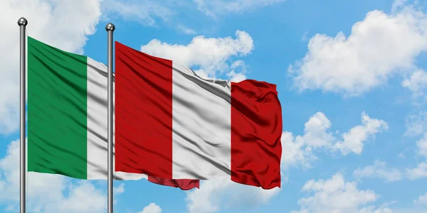 Bandera de Italia y Perú ondeando en el viento contra el cielo azul nublado blanco juntos. Concepto diplomático, relaciones internacionales . — Foto de Stock