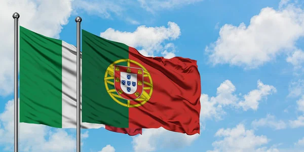 Italien och Portugal flagga viftar i vinden mot vit grumlig blå himmel tillsammans. Begreppet diplomati, internationella förbindelser. — Stockfoto