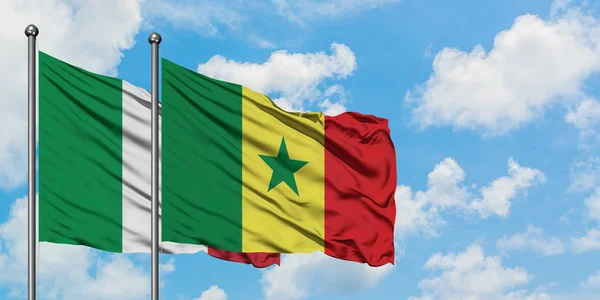 Italien och Senegal flagga viftar i vinden mot vit grumlig blå himmel tillsammans. Begreppet diplomati, internationella förbindelser. — Stockfoto