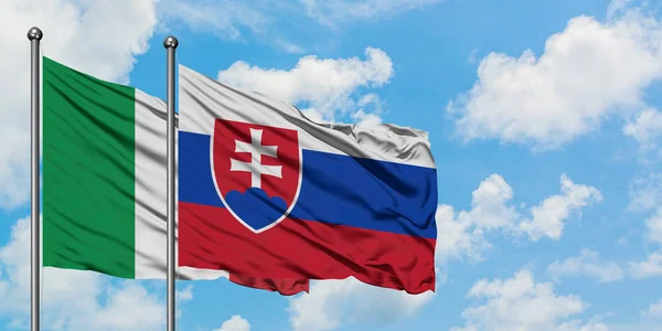 Drapeau de l'Italie et de la Slovaquie agitant dans le vent contre ciel bleu nuageux blanc ensemble. Concept de diplomatie, relations internationales . — Photo