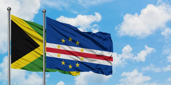 Bandera de Jamaica y Cabo Verde ondeando en el viento contra el cielo azul nublado blanco juntos. Concepto diplomático, relaciones internacionales . — Foto de Stock