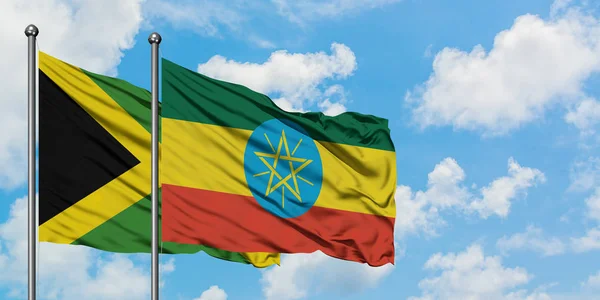 Jamaica and Ethiopia flag waving in the wind against white cloudy blue sky together. Diplomacy concept, international relations. — Stock Photo, Image