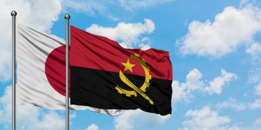 Japonya ve Angola bayrağı birlikte beyaz bulutlu mavi gökyüzüne karşı rüzgarda sallayarak. Diplomasi kavramı, uluslararası ilişkiler.