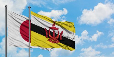 Japonya ve Brunei bayrağı birlikte beyaz bulutlu mavi gökyüzüne karşı rüzgarda sallayarak. Diplomasi kavramı, uluslararası ilişkiler.