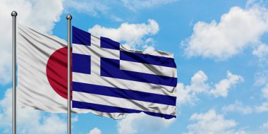 Japonya ve Yunanistan bayrağı birlikte beyaz bulutlu mavi gökyüzüne karşı rüzgarda sallayarak. Diplomasi kavramı, uluslararası ilişkiler.