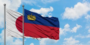 Japonya ve Lihtenştayn bayrağı birlikte beyaz bulutlu mavi gökyüzüne karşı rüzgarda sallayarak. Diplomasi kavramı, uluslararası ilişkiler.