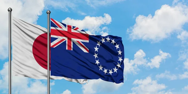 Bandera de Japón e Islas Cook ondeando en el viento contra el cielo azul nublado blanco juntos. Concepto diplomático, relaciones internacionales . —  Fotos de Stock