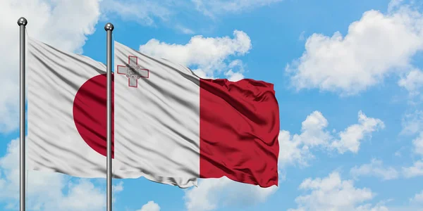Jepang dan Malta mengibarkan bendera dalam angin melawan langit biru berawan putih bersama-sama. Konsep diplomasi, hubungan internasional . — Stok Foto