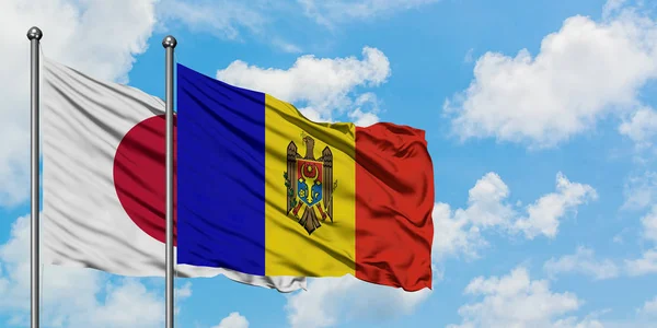 Japonya ve Moldova bayrağı birlikte beyaz bulutlu mavi gökyüzüne karşı rüzgarda sallayarak. Diplomasi kavramı, uluslararası ilişkiler. — Stok fotoğraf