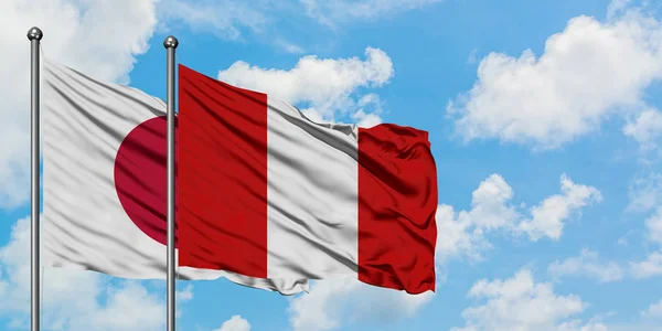 Japan and Peru flag waving in the wind against white cloudy blue sky together. Diplomacy concept, international relations. — Stock Photo, Image