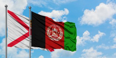 Jersey ve Afganistan bayrağı birlikte beyaz bulutlu mavi gökyüzüne karşı rüzgarda sallayarak. Diplomasi kavramı, uluslararası ilişkiler.
