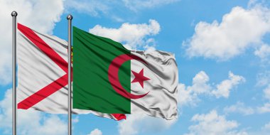 Jersey ve Cezayir bayrağı birlikte beyaz bulutlu mavi gökyüzüne karşı rüzgarda sallayarak. Diplomasi kavramı, uluslararası ilişkiler.