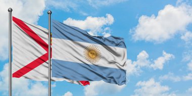 Jersey ve Arjantin bayrağı birlikte beyaz bulutlu mavi gökyüzüne karşı rüzgarda sallayarak. Diplomasi kavramı, uluslararası ilişkiler.