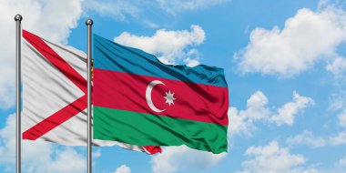 Jersey ve Azerbaycan bayrağı birlikte beyaz bulutlu mavi gökyüzüne karşı rüzgarsal sallayarak. Diplomasi kavramı, uluslararası ilişkiler.