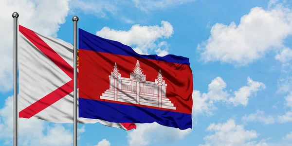 Jersey och Kambodja flagga viftande i vinden mot vit grumlig blå himmel tillsammans. Diplomatisk koncept, internationella relationer. — Stockfoto