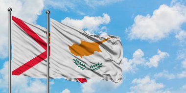 Jersey ve Kıbrıs bayrağı birlikte beyaz bulutlu mavi gökyüzüne karşı rüzgarda sallayarak. Diplomasi kavramı, uluslararası ilişkiler.