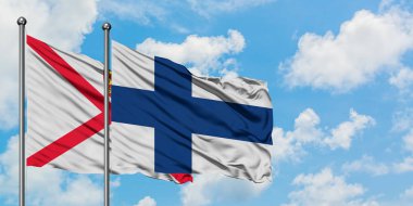 Jersey ve Finlandiya bayrağı birlikte beyaz bulutlu mavi gökyüzüne karşı rüzgarda sallayarak. Diplomasi kavramı, uluslararası ilişkiler.