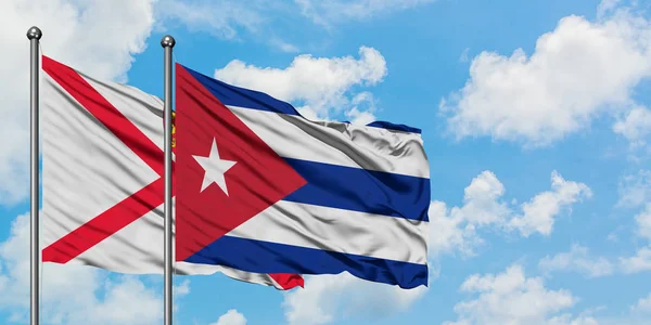 Bandera de Jersey y Cuba ondeando en el viento contra el cielo azul nublado blanco juntos. Concepto diplomático, relaciones internacionales . — Foto de Stock
