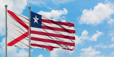 Jersey ve Liberya bayrağı birlikte beyaz bulutlu mavi gökyüzüne karşı rüzgarda sallayarak. Diplomasi kavramı, uluslararası ilişkiler.