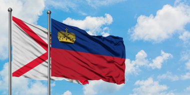 Jersey ve Liechtenstein bayrağı birlikte beyaz bulutlu mavi gökyüzüne karşı rüzgarda sallayarak. Diplomasi kavramı, uluslararası ilişkiler.