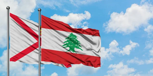 De vlag van Jersey en Libanon zwaaiende in de wind tegen witte bewolkte blauwe hemel samen. Diplomatie concept, internationale betrekkingen. — Stockfoto