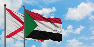 Jersey ve Sudan bayrağı birlikte beyaz bulutlu mavi gökyüzüne karşı rüzgarda sallayarak. Diplomasi kavramı, uluslararası ilişkiler.