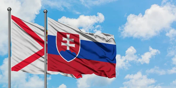 Jersey och Slovakien flagga vifta i vinden mot vit grumlig blå himmel tillsammans. Diplomatisk koncept, internationella relationer. — Stockfoto