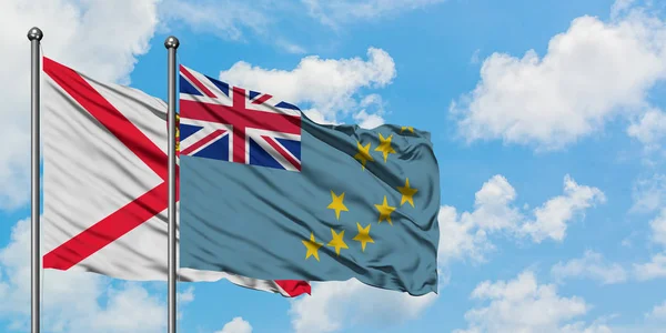 Bandera de Jersey y Tuvalu ondeando en el viento contra el cielo azul nublado blanco juntos. Concepto diplomático, relaciones internacionales . — Foto de Stock