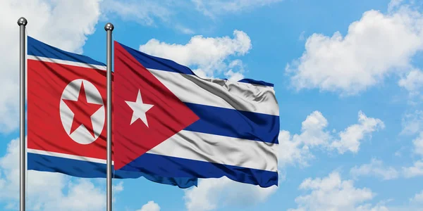 Bandera de Corea del Norte y Cuba ondeando en el viento contra el cielo azul nublado blanco juntos. Concepto diplomático, relaciones internacionales . —  Fotos de Stock