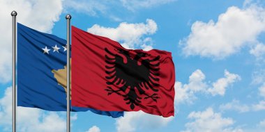Kosova ve Arnavutluk bayrağı birlikte beyaz bulutlu mavi gökyüzüne karşı rüzgarda sallayarak. Diplomasi kavramı, uluslararası ilişkiler.