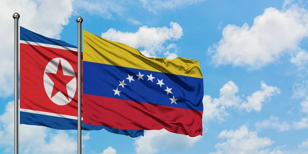 North Korea and Venezuela flag waving in the wind against white cloudy blue sky together. Diplomacy concept, international relations. — Stock Photo, Image