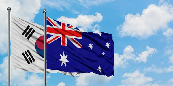 Bandera de Corea del Sur y Australia ondeando en el viento contra el cielo azul nublado blanco juntos. Concepto diplomático, relaciones internacionales . —  Fotos de Stock