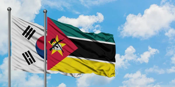 Coréia do Sul e bandeira de Moçambique agitando no vento contra o céu azul nublado branco juntos. Conceito de diplomacia, relações internacionais . — Fotografia de Stock