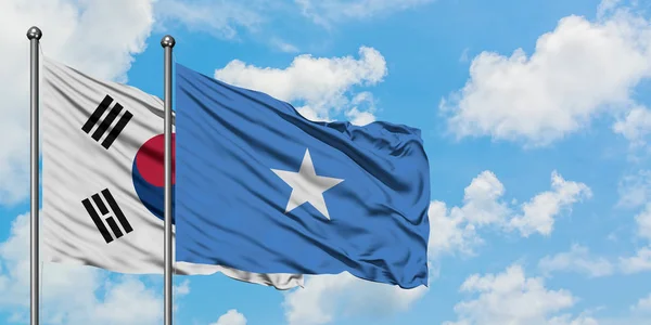 Güney Kore ve Somali bayrağı birlikte beyaz bulutlu mavi gökyüzüne karşı rüzgarsal sallayarak. Diplomasi kavramı, uluslararası ilişkiler. — Stok fotoğraf