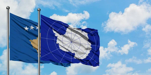 Bandera de Kosovo y la Antártida ondeando en el viento contra el cielo azul nublado blanco juntos. Concepto diplomático, relaciones internacionales . — Foto de Stock