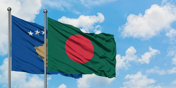 Bandera de Kosovo y Bangladesh ondeando en el viento contra el cielo azul nublado blanco juntos. Concepto diplomático, relaciones internacionales . — Foto de Stock