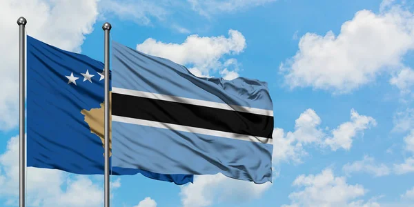 Kosovo and Botswana flag waving in the wind against white cloudy blue sky together. Diplomacy concept, international relations. — Stock Photo, Image