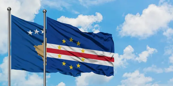 Bandera de Kosovo y Cabo Verde ondeando en el viento contra el cielo azul nublado blanco juntos. Concepto diplomático, relaciones internacionales . — Foto de Stock