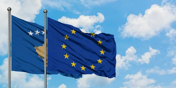 Kosovo e a bandeira da União Europeia agitando no vento contra o céu azul nublado branco juntos. Conceito de diplomacia, relações internacionais . — Fotografia de Stock
